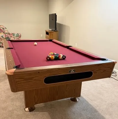 Oak table with burgundy felt in a carpeted basement